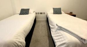 twee bedden naast elkaar in een kamer bij IR Icon Brentwood Town in Brentwood