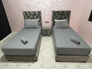 two beds sitting next to each other in a room at Appartement centre-ville avec Wifi 100 Mo in Fès +9 photos