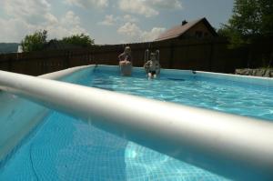 two people are standing in a swimming pool at Domki na Polach Piwniczna-Zdrój in Piwniczna