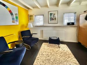 a living room with blue chairs and a rug at Polderhuus Galatheapolder in Achthuizen