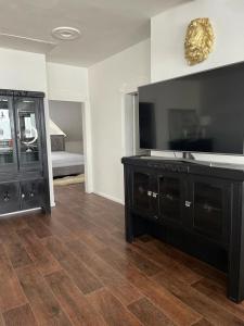 uma sala de estar com uma televisão de ecrã plano e uma cómoda em Apartmán em Kadaň