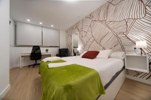 een slaapkamer met een bed met een groene deken erop bij Vizcainos Garden in Segovia