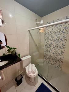 uma casa de banho com um WC e uma cabina de duche em vidro. em Kitnet na Vila de Manguinhos em Serra