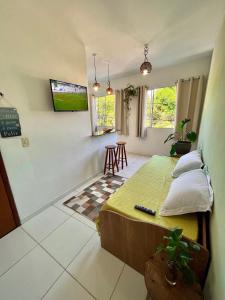 Un dormitorio con una cama y una mesa. en Kitnet na Vila de Manguinhos, en Serra