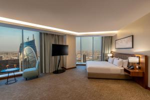 um quarto de hotel com uma cama e uma grande janela em HDB Financial District em Riade