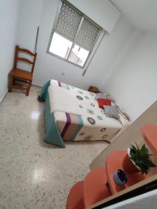 ein kleines Schlafzimmer mit einem Bett und einem Stuhl in der Unterkunft Habitación Privada Juan in Estepona