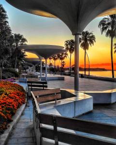a park with benches and a sunset in the background at Habitación Privada Juan in Estepona
