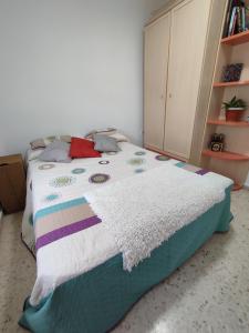 ein Schlafzimmer mit einem Bett mit einer bunten Decke darauf in der Unterkunft Habitación Privada Juan in Estepona