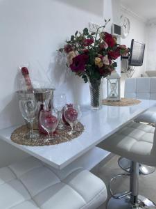 a table with wine glasses and a vase with flowers at צימר אלין בכפר in Kiryat Ekron
