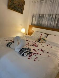 a bed with roses on it and stuffed animals on it at צימר אלין בכפר in Kiryat Ekron