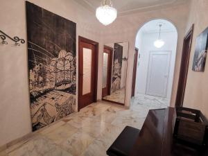 a room with a painting on the wall and a hallway at Appartamento a 20 minuti dal Centro, Zona Residenziale Tranquilla, Free Parking, 2 Camere, 5 posti letto in Turin