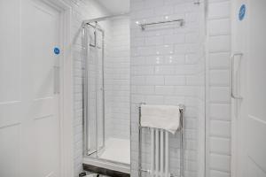 a white bathroom with a shower with a glass door at Urban Elegance - Luxe 1-Bed Haven in Hartlepool in Hartlepool