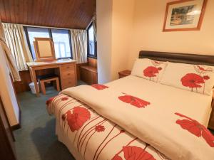 a bedroom with a bed with red flowers on it at 9 Camden Building in Kendal