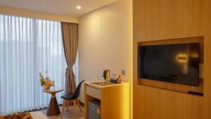 um quarto de hotel com uma grande televisão de ecrã plano na parede em Shenzhen Tower Hotel Thonglor Sukhumvit em Bangkok