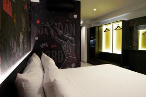 Un dormitorio con una cama blanca y una pared con graffiti en SO City Hotel Adults Only, en San Julián