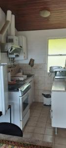 uma pequena cozinha com um fogão e uma janela em Linda Casa 2D 1B em Viña del Mar