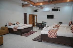 a living room with two beds and a tv at Panambi Tapovan Resort in Rishīkesh