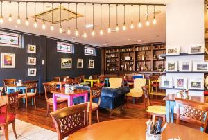 a restaurant with tables and chairs in a room at The Donard Hotel in Newcastle