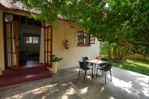 a table and chairs in front of a house at 2 bed apartment with pool - 2126 in Victoria Falls