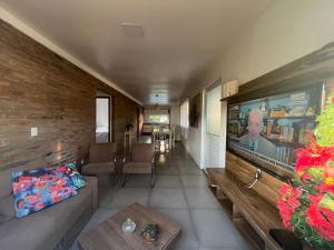 sala de estar con TV de pantalla plana grande en Casa com piscina em Torres, en Torres