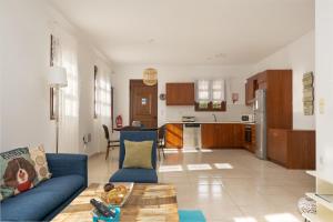 a living room with a blue couch and a kitchen at Lindos Aeonian Villas in Lindos