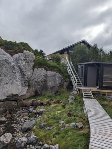 a house on a hill with a wooden walkway at Nydelig hytte med fantastisk beliggenhet ved sjøen in Laupstad