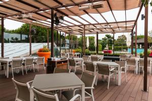 リンダ・ア・ヴェーリャにあるMS Aparthotelのテーブルと椅子のあるレストラン、プールを提供しています。