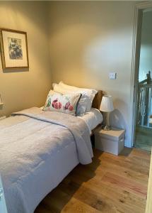 a bedroom with a bed and a lamp on a table at Ty Llew Lodge in Abergavenny