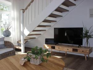 a living room with a tv and a staircase at Cathedral day "Hygge" in Kronsgaard