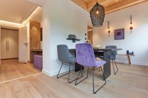 a dining room with a table and purple chairs at DAS SALZBERG Hideaway Bad Aussee - Adults only in Bad Aussee
