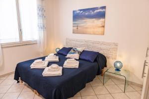 - une chambre avec un lit bleu et des serviettes dans l'établissement Baia Blu RTA Residence, à Lerici