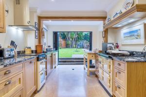 a large kitchen with wooden cabinets and a large window at High quality detached house with parking St. Ives in St Ives