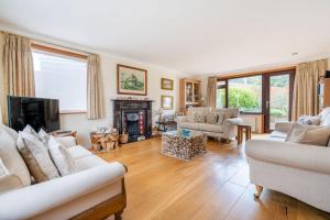 a living room with white furniture and a fireplace at High quality detached house with parking St. Ives in St Ives