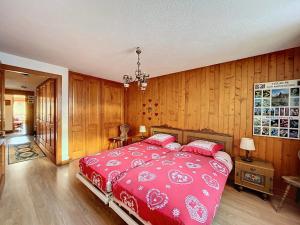 a bedroom with a red bed with wooden walls at Ambassador 102 in Verbier