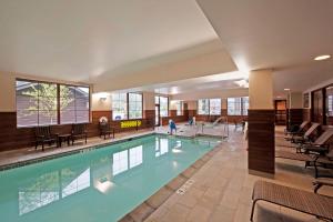 ein großer Pool in einem Gebäude mit Stühlen in der Unterkunft Hampton Inn & Suites Lake Placid in Lake Placid