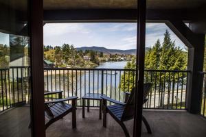 a balcony with two chairs and a view of a river at Hampton Inn & Suites Lake Placid in Lake Placid