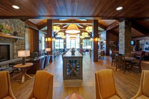 eine Lobby mit einem Tisch, Stühlen und einem Kamin in der Unterkunft Hampton Inn & Suites Lake Placid in Lake Placid