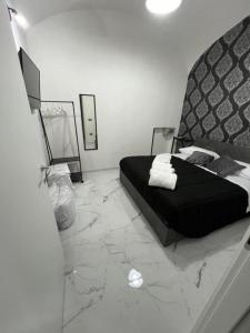B&B Puma official في نابولي: غرفة نوم بسرير أسود وأرضية من الرخام