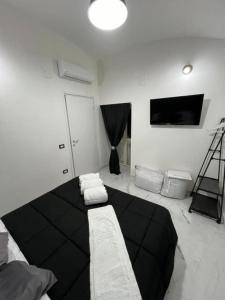 B&B Puma official في نابولي: غرفة معيشة مع سرير أسود وتلفزيون