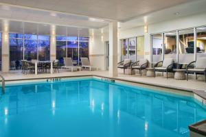 a pool with chairs and a table in a hotel at Hilton Garden Inn Schaumburg in Schaumburg