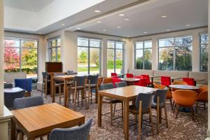 a restaurant with tables and chairs and windows at Hilton Garden Inn Schaumburg in Schaumburg