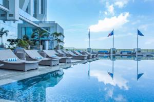 uma piscina com espreguiçadeiras ao lado de um edifício em Hilton Panama em Cidade do Panamá