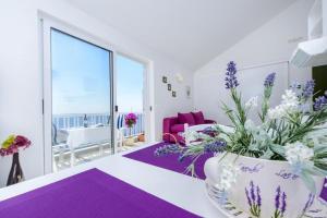 una sala de estar de color púrpura y blanco con un jarrón de flores en Kate's Place, en Dubrovnik