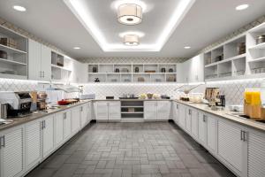 a large kitchen with white cabinets and a tile floor at Hyatt Place Iowa City Downtown in Iowa City