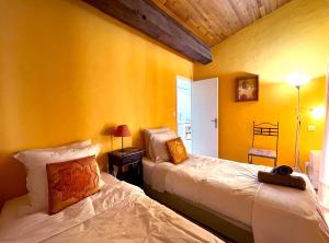 two beds in a room with yellow walls at Bordeaux Terrace in Bordeaux