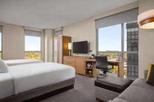 um quarto de hotel com uma cama e uma secretária com uma televisão em Hyatt Place Iowa City Downtown em Iowa City