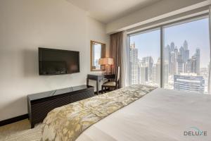 a bedroom with a bed and a desk and a large window at Posh 1BR at The Address Residences Dubai Marina by Deluxe Holiday Homes in Dubai