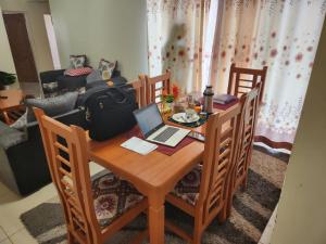 a dining room table with a laptop computer on it at Prime Homes in Eldoret