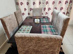 a wooden table with two chairs and a table at Prime Homes in Eldoret