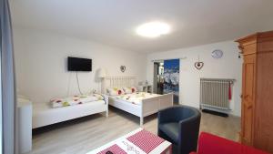 ein kleines Zimmer mit 2 Betten und einem Stuhl in der Unterkunft Hotel Garni Haus Alpine - Chiemgau Karte inkl in Ruhpolding